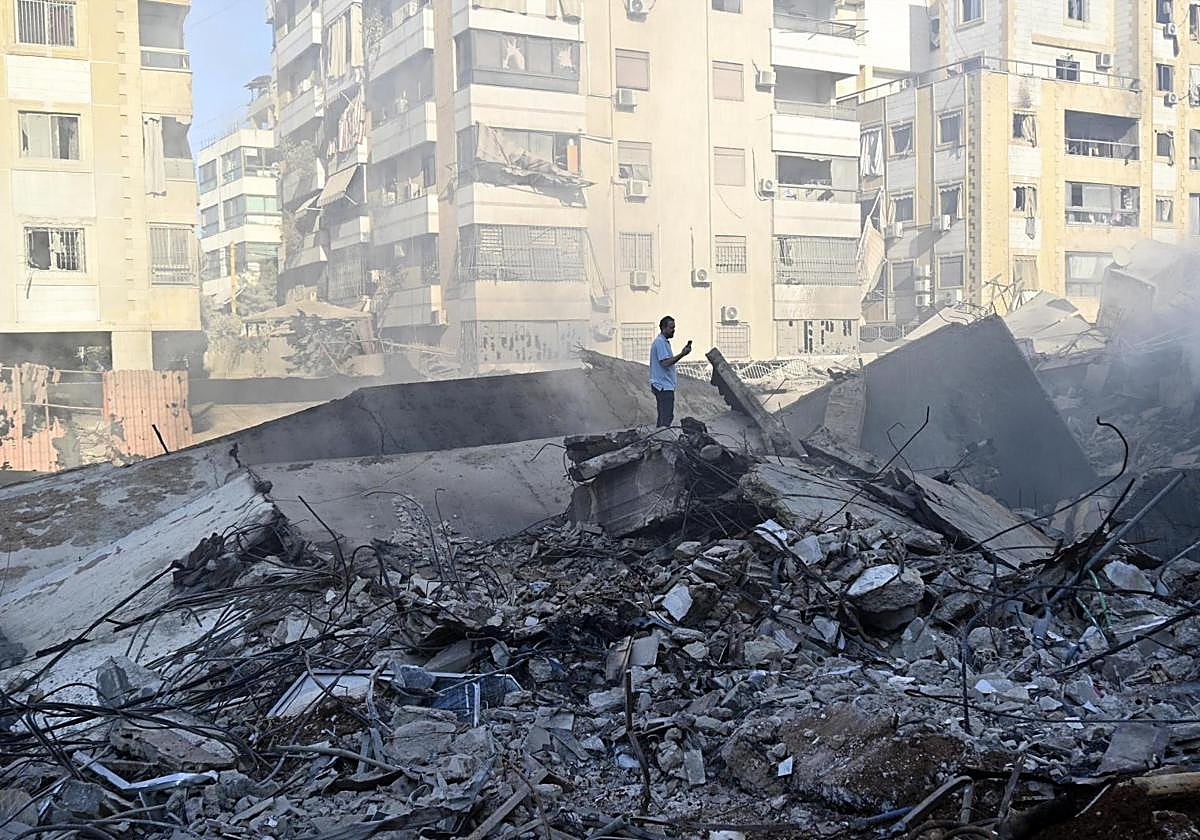 Un hombre inspecciona los edificios destruidos en uno de los suburbios del sur de Beirut