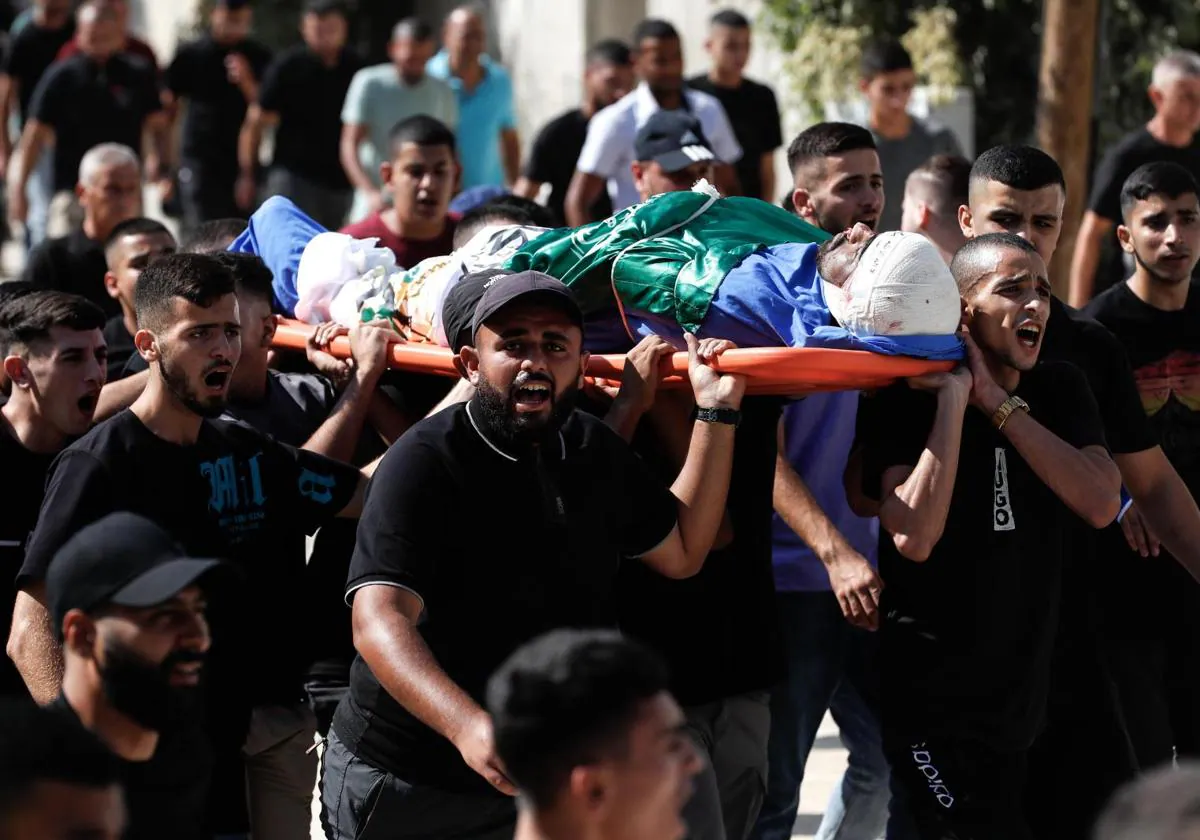 Allegados portan el cuerpo de uno de los palestinos muertos tras un ataque israelí este viernes