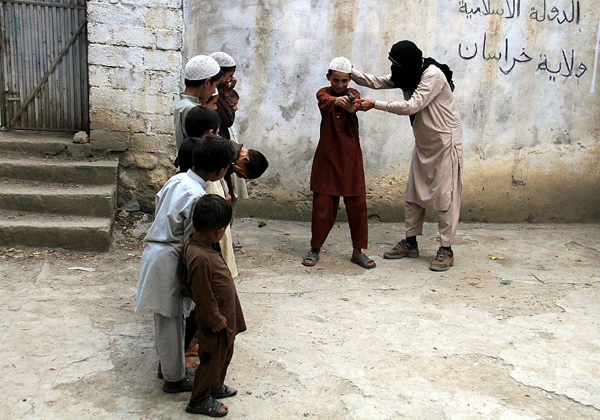 Un militante del Daesh se divierte con los hijos de otros militantes en  Kunar, Afganistán, en una foto de archivo