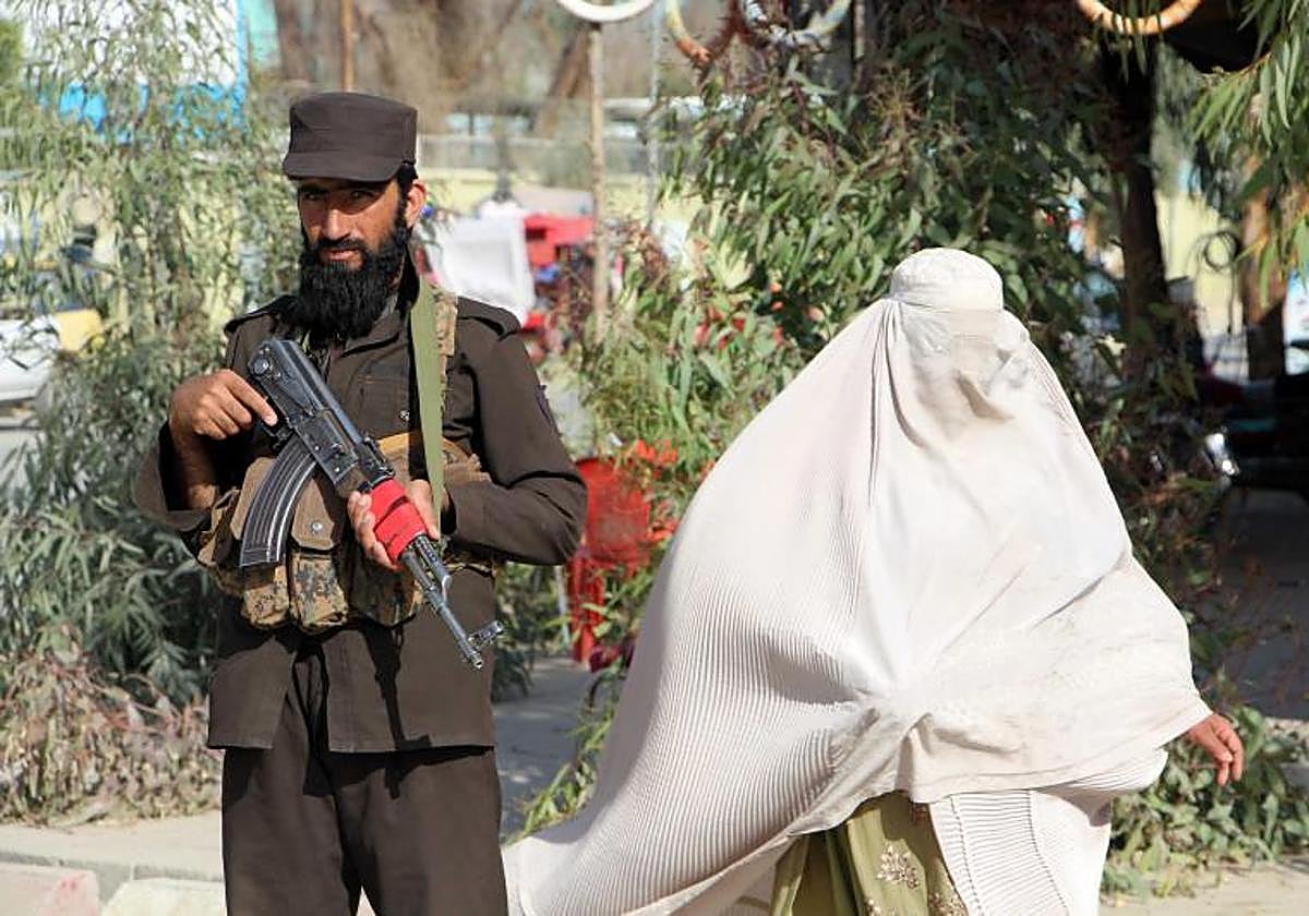 Una mujer vestida con burka cerca de un puesto de control en Kandahar, Afganistán