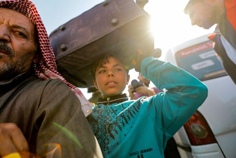 Los sirios que estaban refugiados en el Líbano regresan a su país de origen después de un viaje a la provincia norteña de Idlib, controlada por la oposición, a través del cruce de Aoun al-Dadat, al norte de Manbij