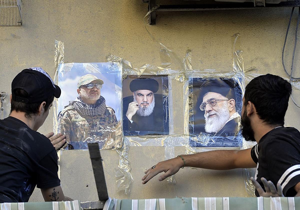Fotografías de Nasralá (centro), y del líder supremo iraní, el ayatolá Ali Jamenei (derecha), en la pared de un edificio en el distrito de Dahieh