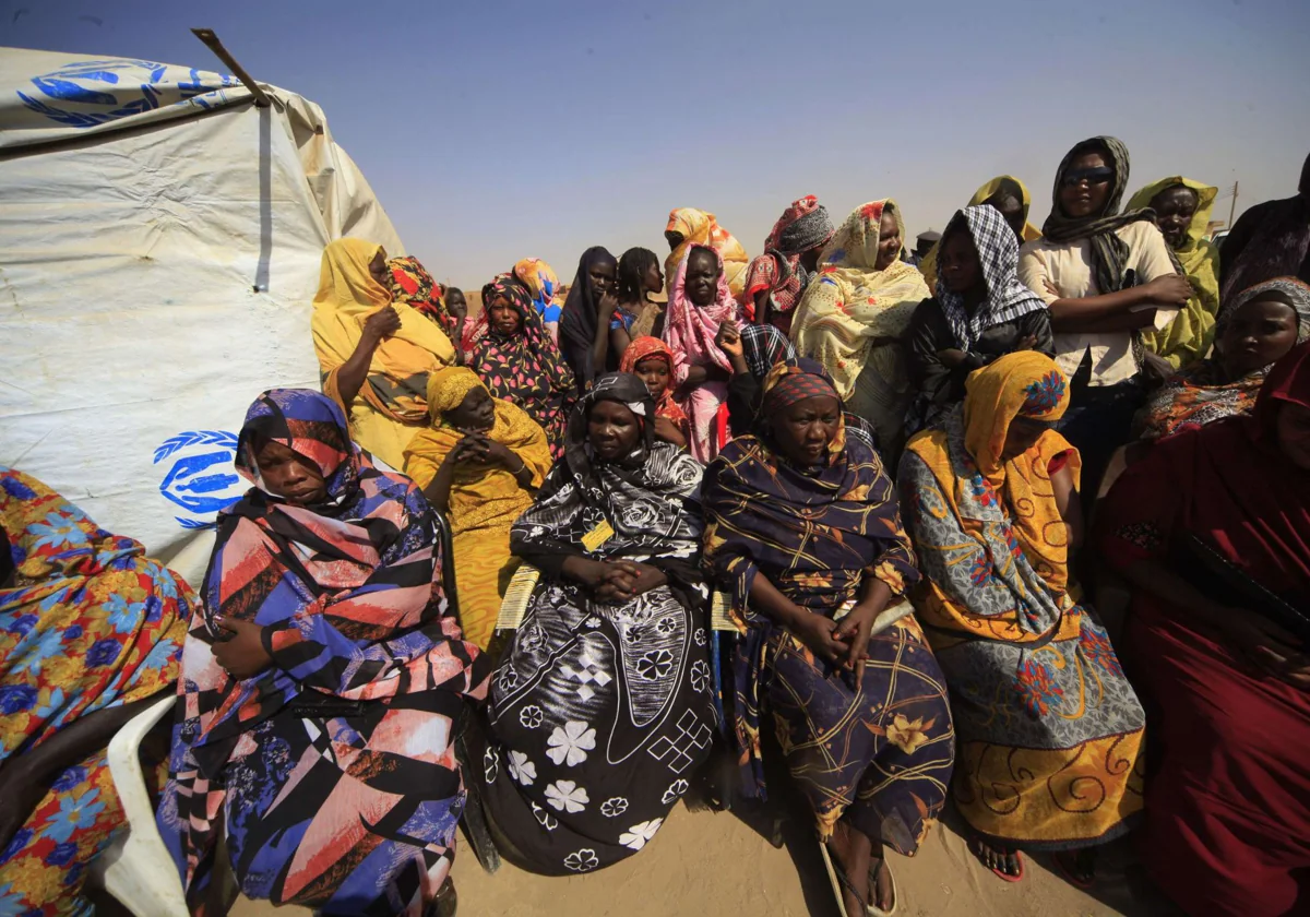 Un grupo de sursudaneses esperan fuera de su tienda de campaña en el campamento en Jartum, en una foto de archivo