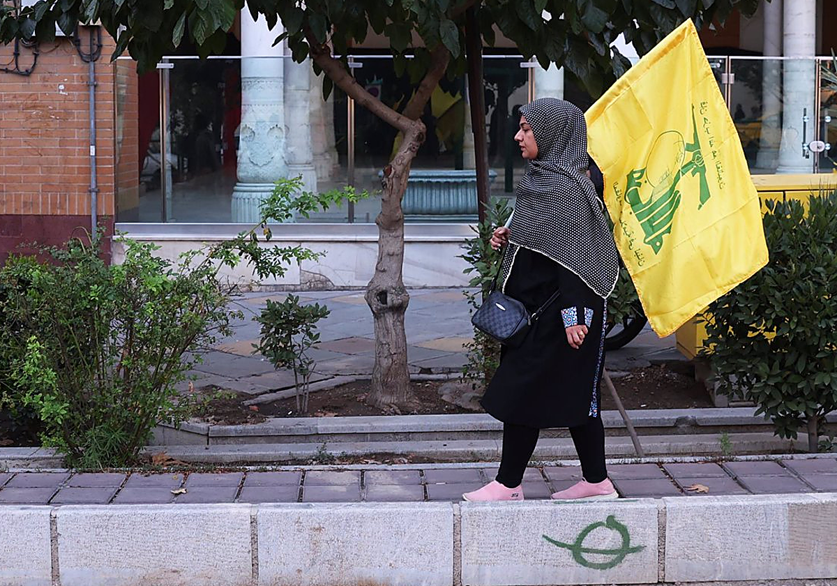 Una mujer en Irán con una bandera del partido-milicia chií libanés Hizbolá