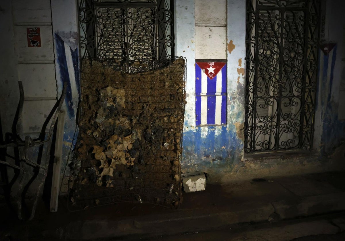 Un colchón dañado junto a una bandera de Cuba durante un apagón hace dos semanas, en La Habana