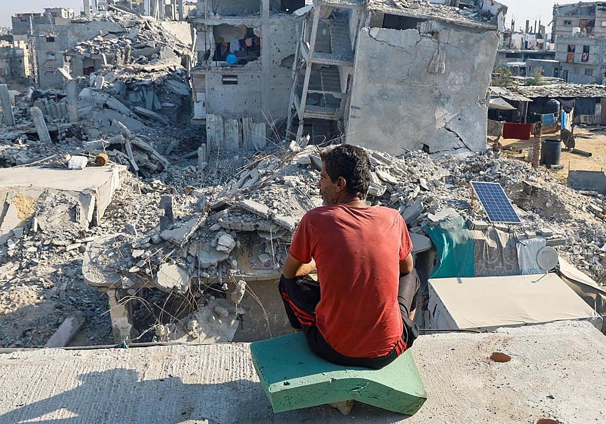 Un palestino sentado sobre los escombros de una casa destruida en Khan Younis