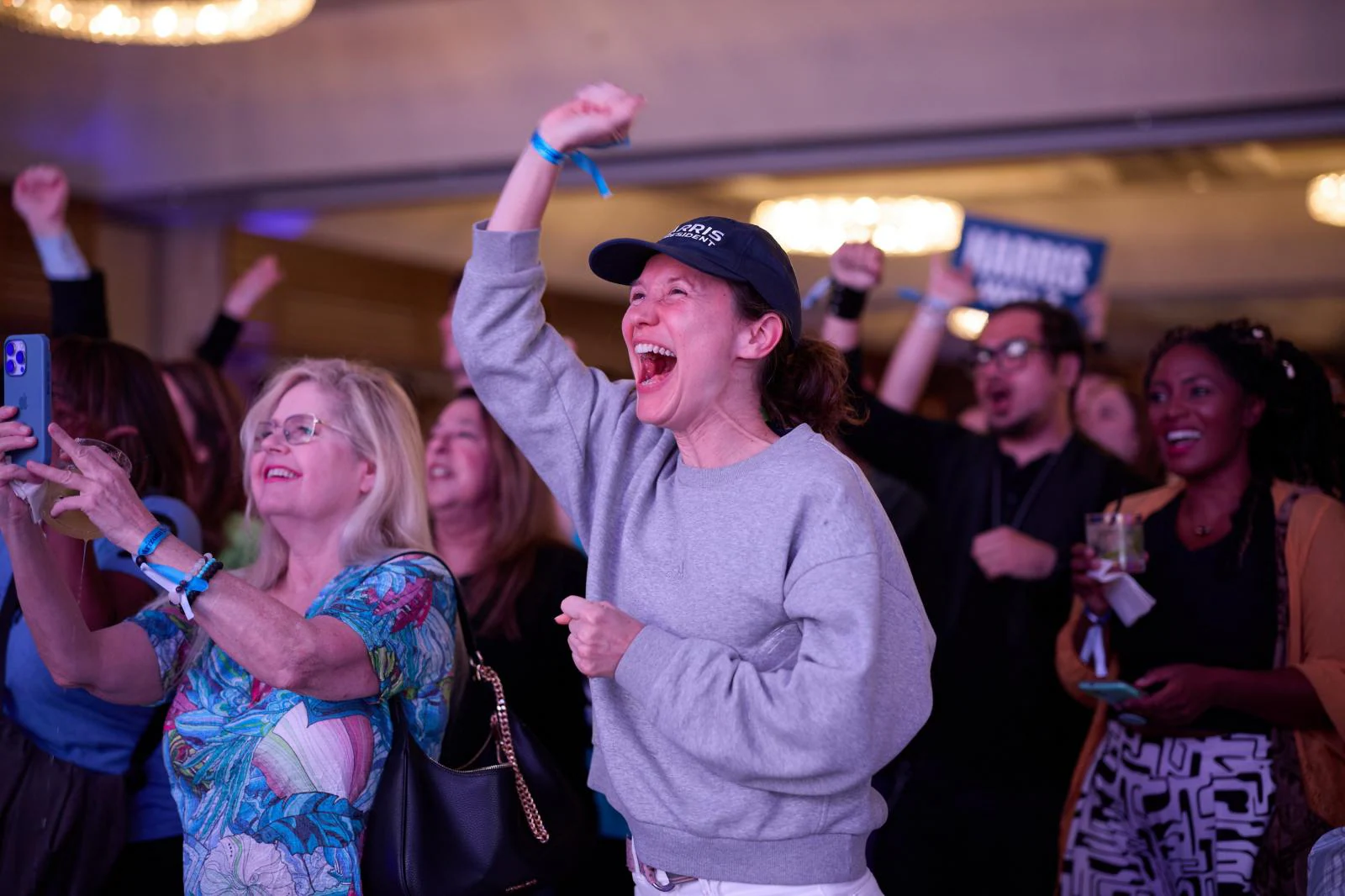 Gente aplaudiendo al escuchar los escasos buenos resultados de Kamala Harris 