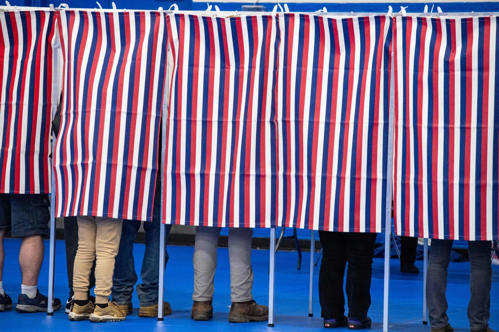 Varias personas rellenan sus papeletas en las cabinas de votación del Centro Comunitario de Green Street en Concord, Nuevo Hampshire