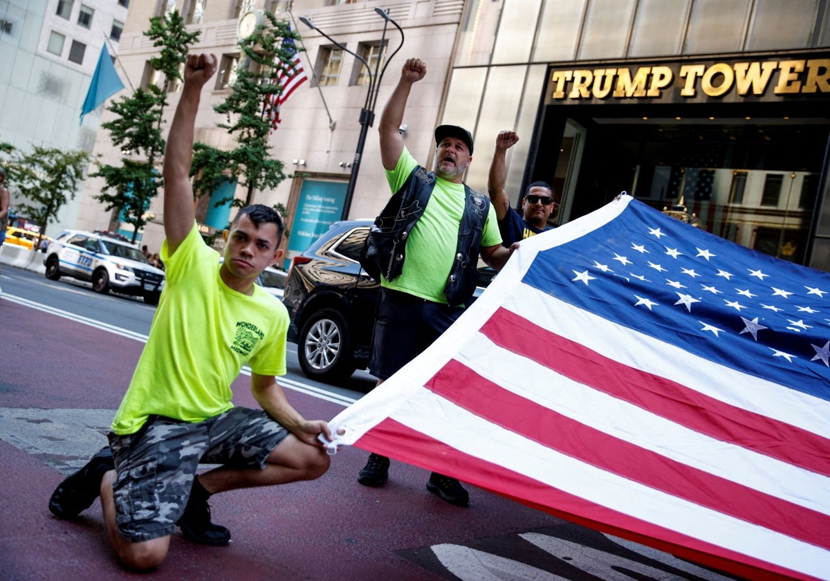 Varias personas sostienen la bandera de EE.UU. frente a la Trump Tower en Nueva York