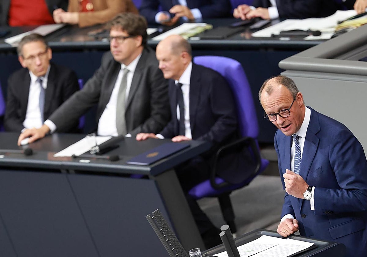 El canciller alemán, Olaf Scholz, escucha al líder de la CDU, Friedich Merz, en el Bundestag