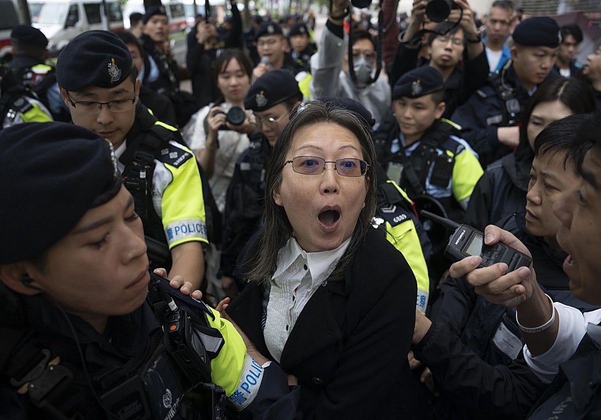 Una mujer es detenida por la policía frente al Tribunal de Magistrados de West Kowloon en Hong Kong