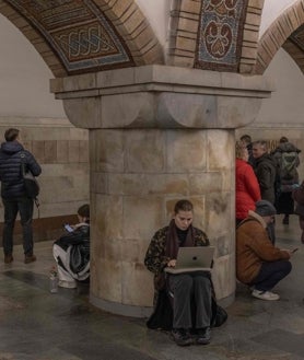 Imagen secundaria 2 - Una mujer usa su computadora portátil mientras se refugia en una estación de metro durante una alarma de ataque aéreo en Kiev