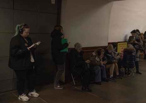 Imagen secundaria 1 - Una mujer usa su computadora portátil mientras se refugia en una estación de metro durante una alarma de ataque aéreo en Kiev