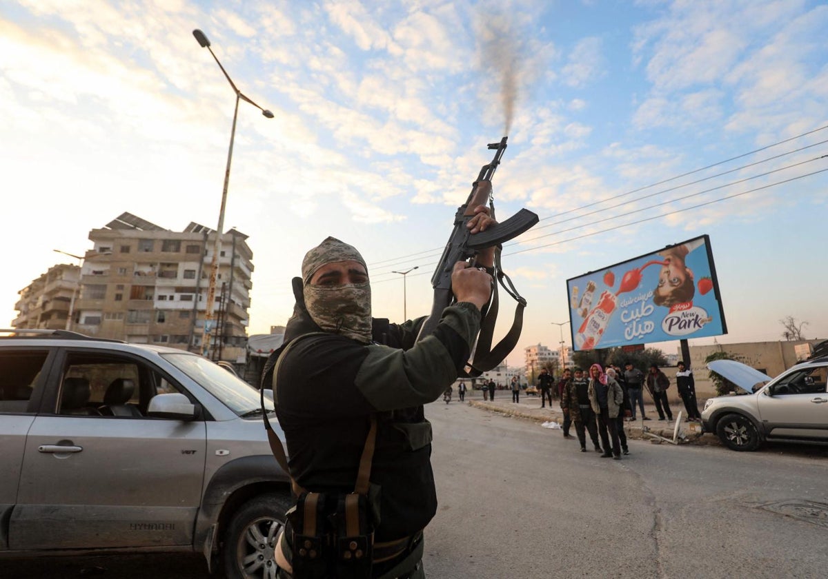 Un miliciano rebelde dispara su fusil en una calle de la ciudad siria de Hama