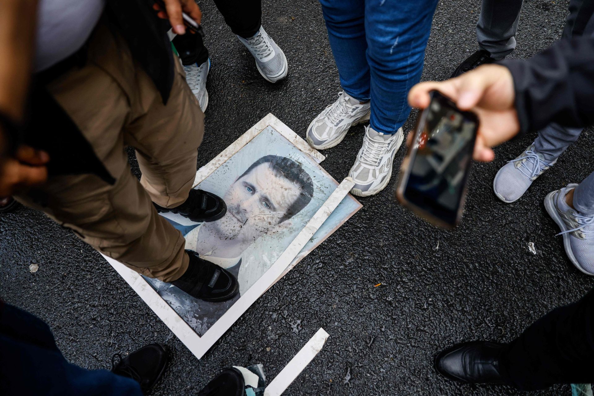 Un manifestante se para sobre una fotografía del presidente Bashar al-Assad durante una protesta frente al consulado sirio en Estambu