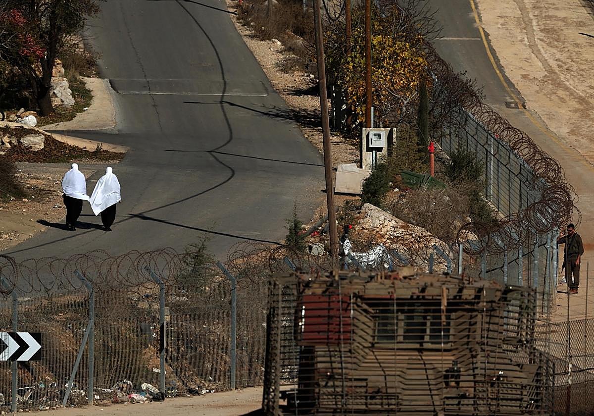 Dos mujeres psean por la frontera vallada de enter Siria e Israel.