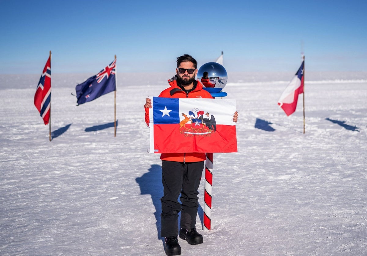 Boric durante su visita en el Polo Sur, con una bandera chilena