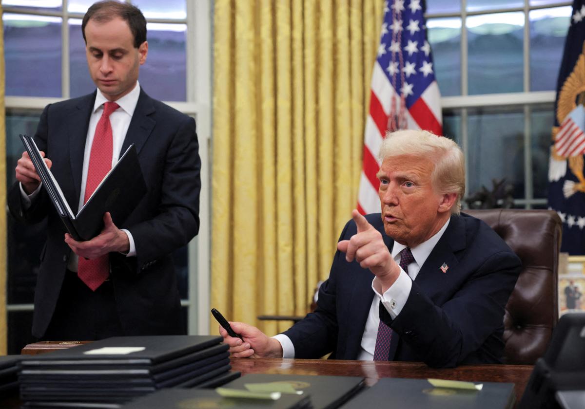 El presidente de Estados Unidos, Donald Trump, firmando sus primeras órdenes ejecutivas en el Despacho Oval