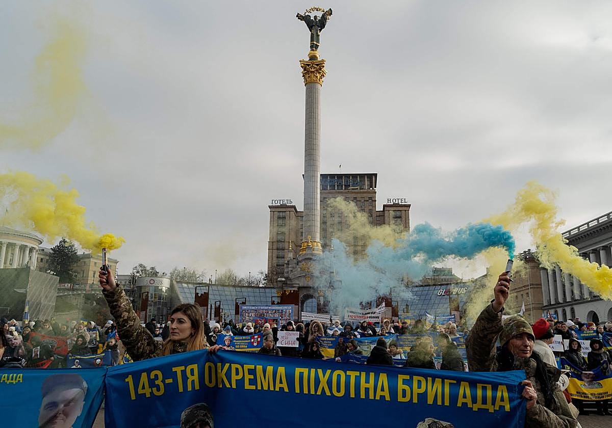Manifestantes sostienen bengalas y carteles durante una manifestación en apoyo a los soldados desaparecidos