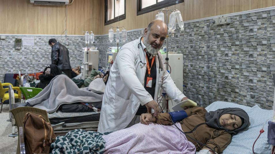Taher, médico y jefe de la sección de diálisis, trata a una mujer enferma en el hospital de Idlib