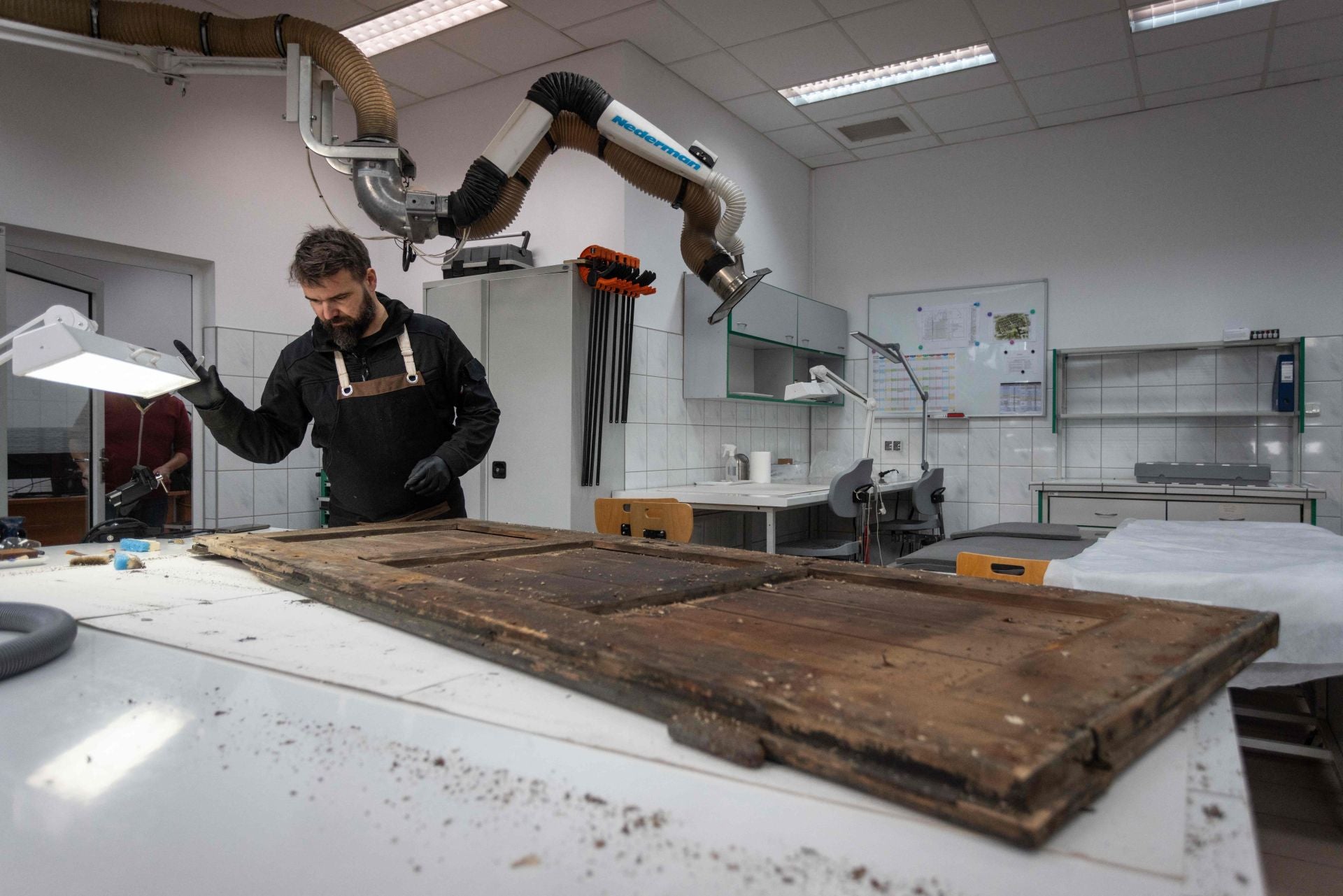 Andrzej Jastrzebiowski, de 47 años, conservador del Memorial y Museo de Auschwitz-Birkenau, trabaja en la preservación de la puerta de madera de una cocina del campo