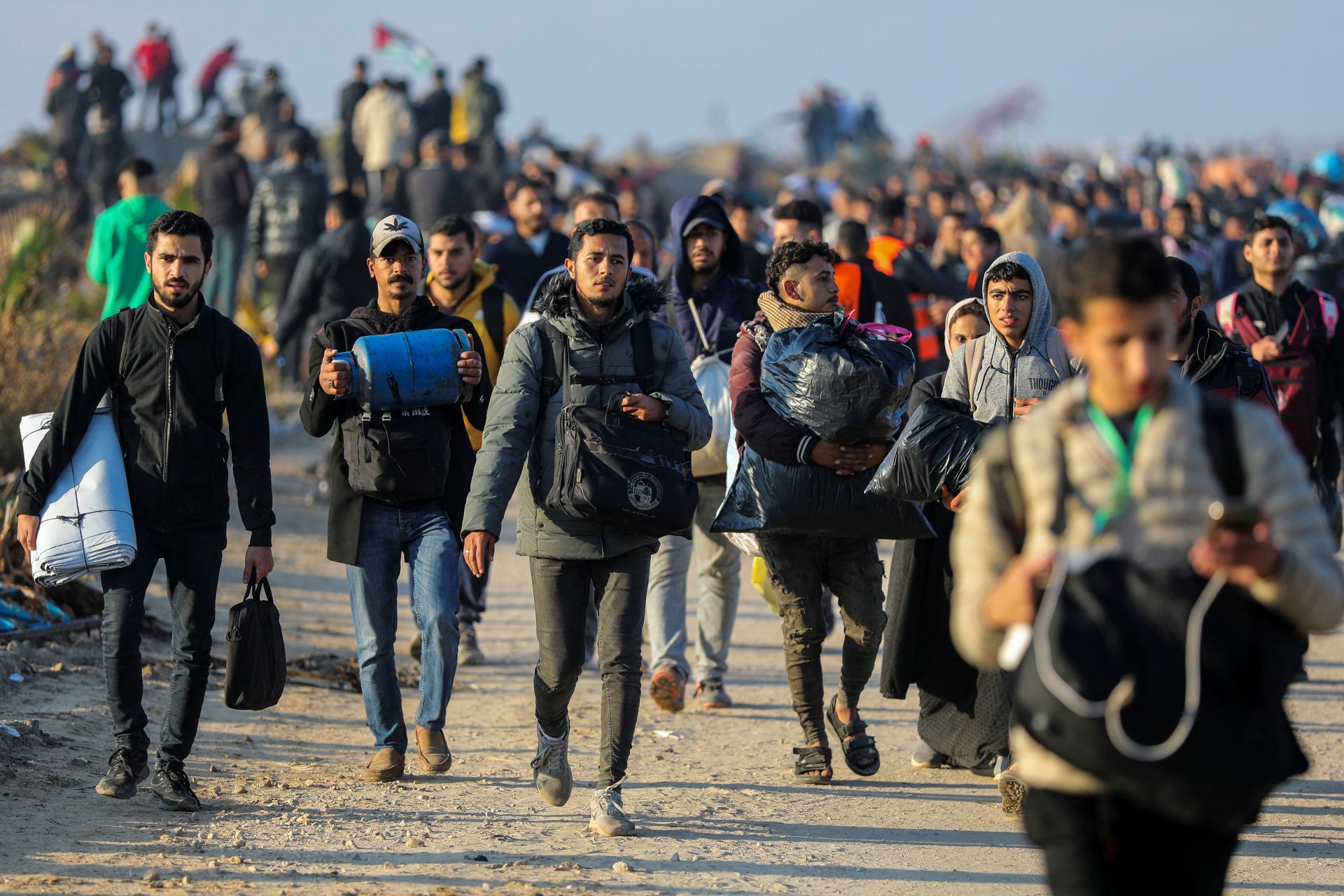 Los palestinos, que fueron desplazados hacia el sur por orden de Israel durante la guerra, llegan a pie mientras regresan a sus hogares en el norte de Gaza, en medio de un alto el fuego entre Israel y Hamás, en la ciudad de Gaza.