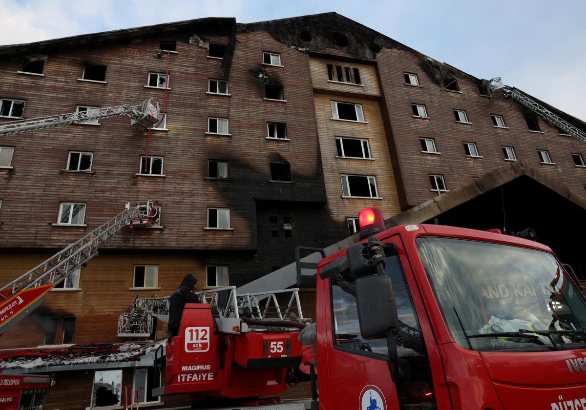 Los bomberos trabajan en el hotel incendiado.