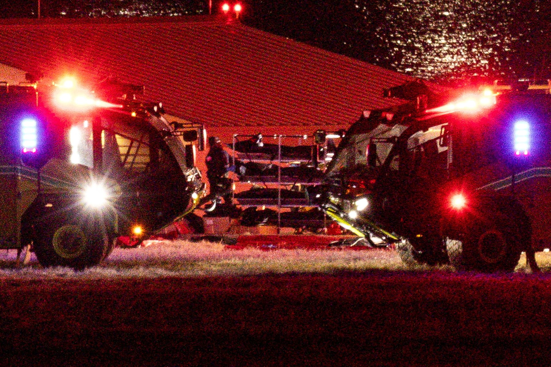Los cuerpos son transportados junto a vehículos de emergencia, cerca del lugar del accidente.