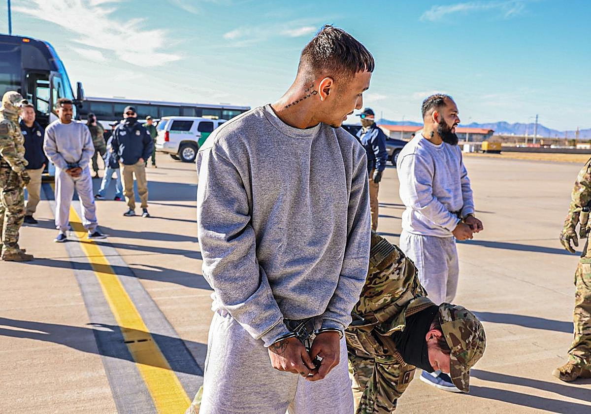 Soldados del ejército estadounidense escoltan a varios inmigrantes en Guantánamo