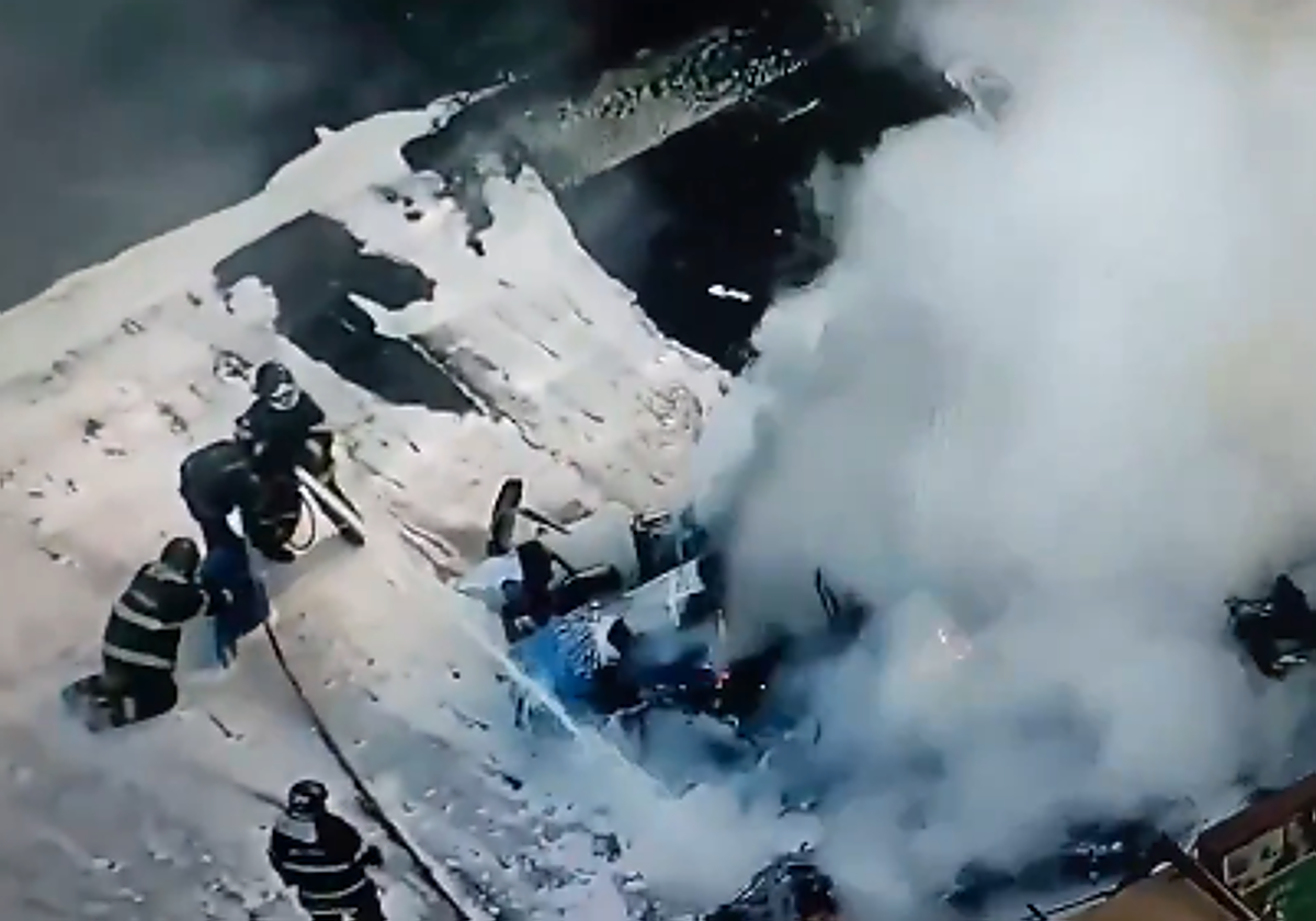 Los bomberos apagan el fuego provocado por el accidente.