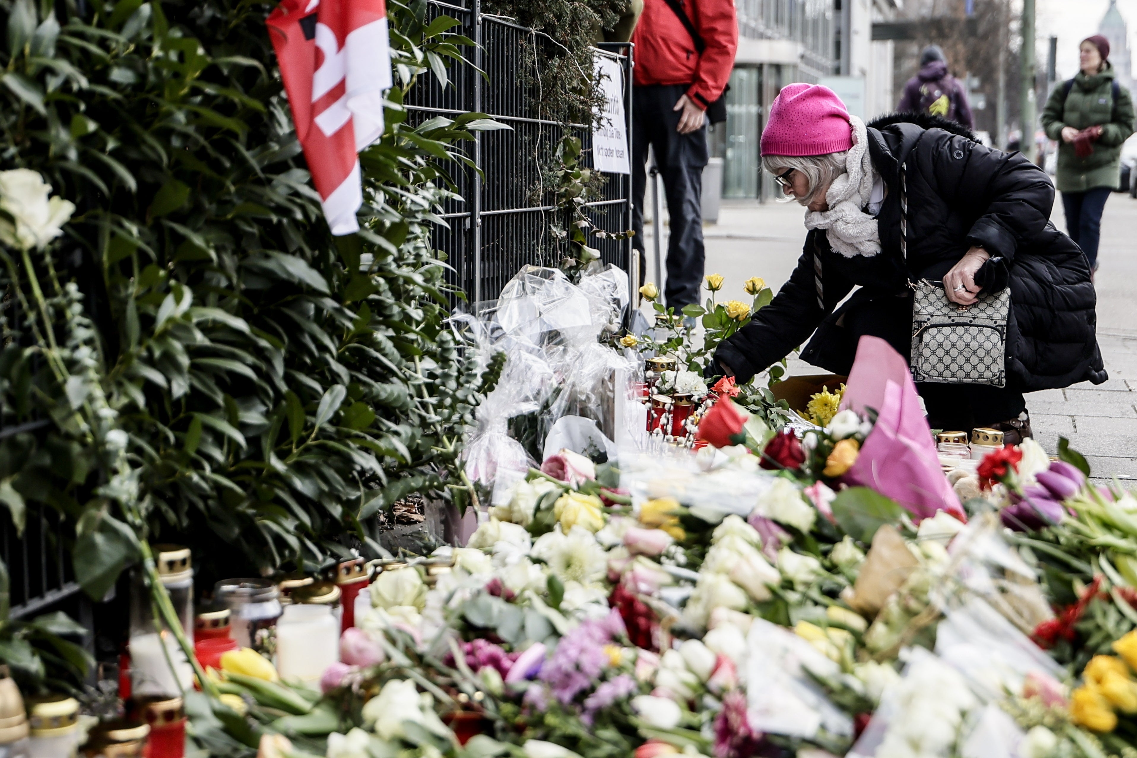 Una mujer deposita flores en el lugar del atropello