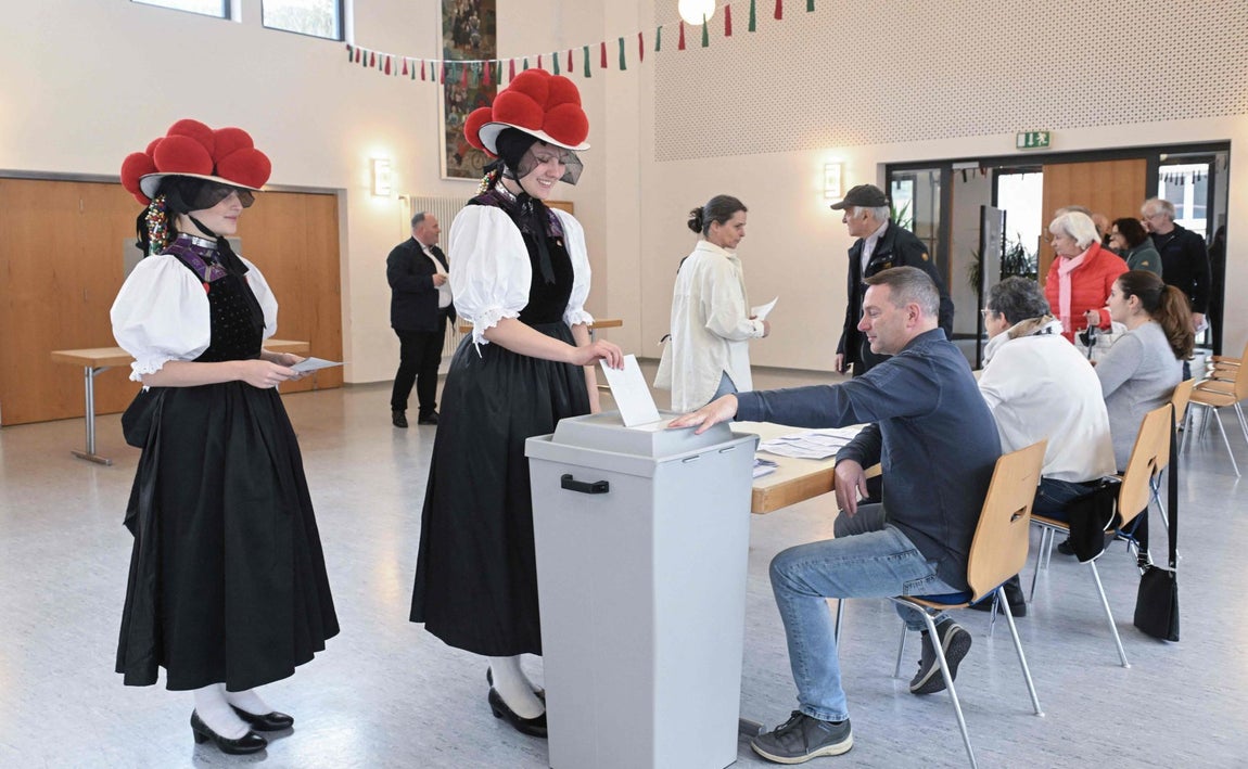 Dos mujeres votan con un traje tradicional denominado 'Bollenhut'
