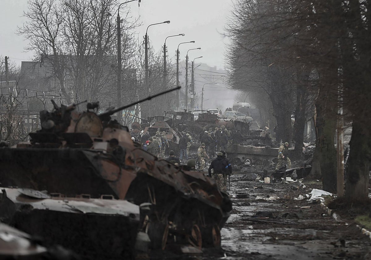 Los militares ucranianos inspeccionan los vehículos rusos, destruidos durante la recaptura de Bucha (Ucrania), en 2022