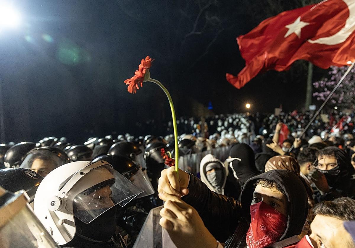 Manifestantes muestran una flor a los agentes de policía.