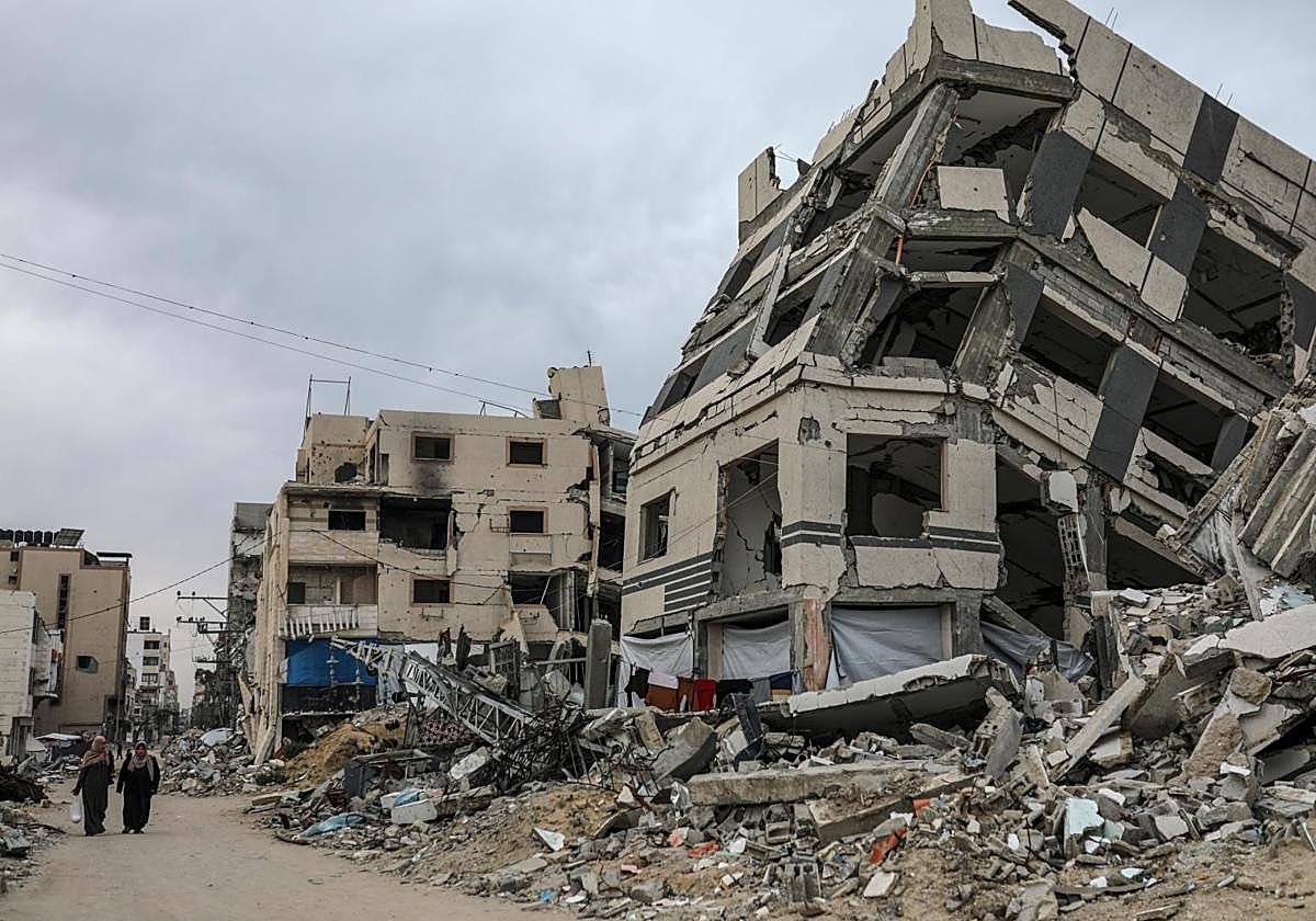 Desplazados internos palestinos caminan por una calle cerca de los escombros de edificios destruidos tras huir del norte de Gaza después de una orden de evacuación del ejército israelí