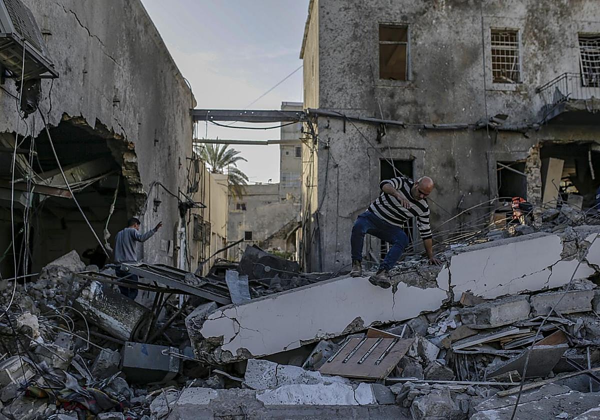 Palestinos inspeccionan el edificio destruido del hospital baptista Al Ahli tras un ataque aéreo israelí en la ciudad de Gaza