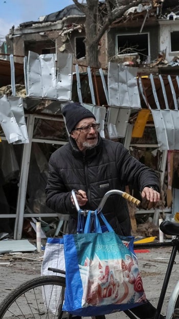 Un residente tira de una bicicleta cerca de los edificios dañados por ataques rusos en Pokrovsk