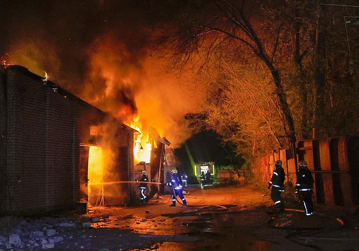 Varios bomberos intentan apagar el fuego provocado por un ataque ruso en una vivienda en Járkov