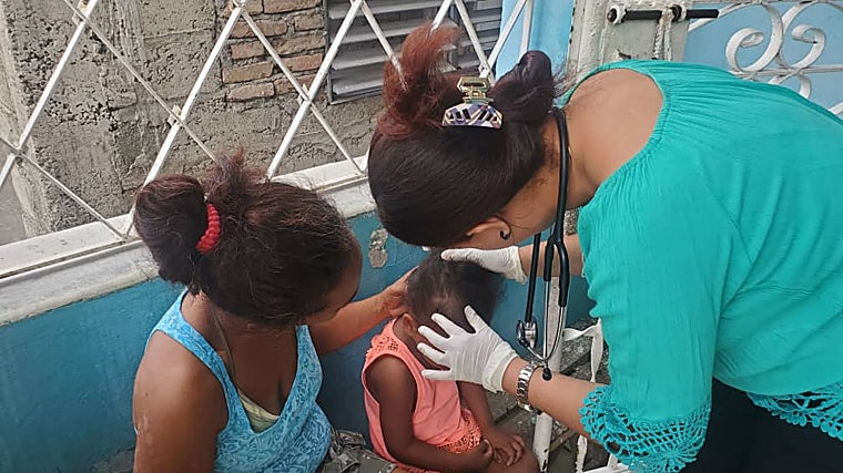 La doctora Ortega atiende a una niña en presencia de su madre