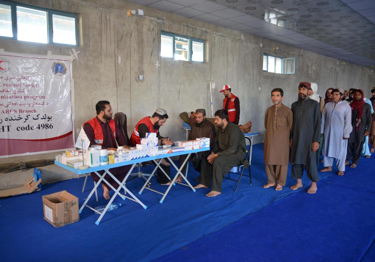 El personal sanitario de la Cruz Roja examina a los refugiados afganos a su llegada desde Pakistán