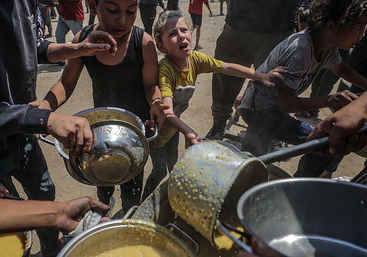 Palestinos desplazados recogen alimentos donados en Jabalia, norte de Gaza