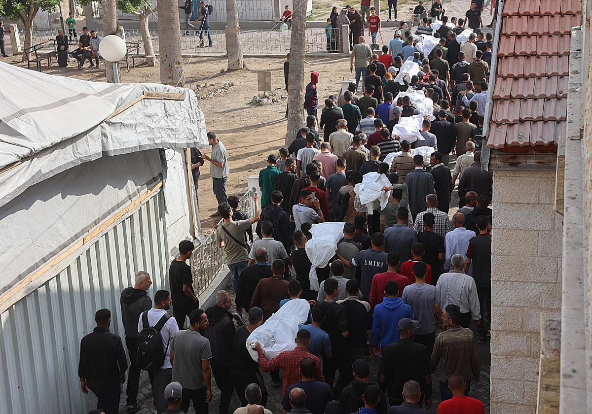 Palestinos caminan en procesión fúnebre tras un ataque israelí que alcanzó una escuela de la UNRWA