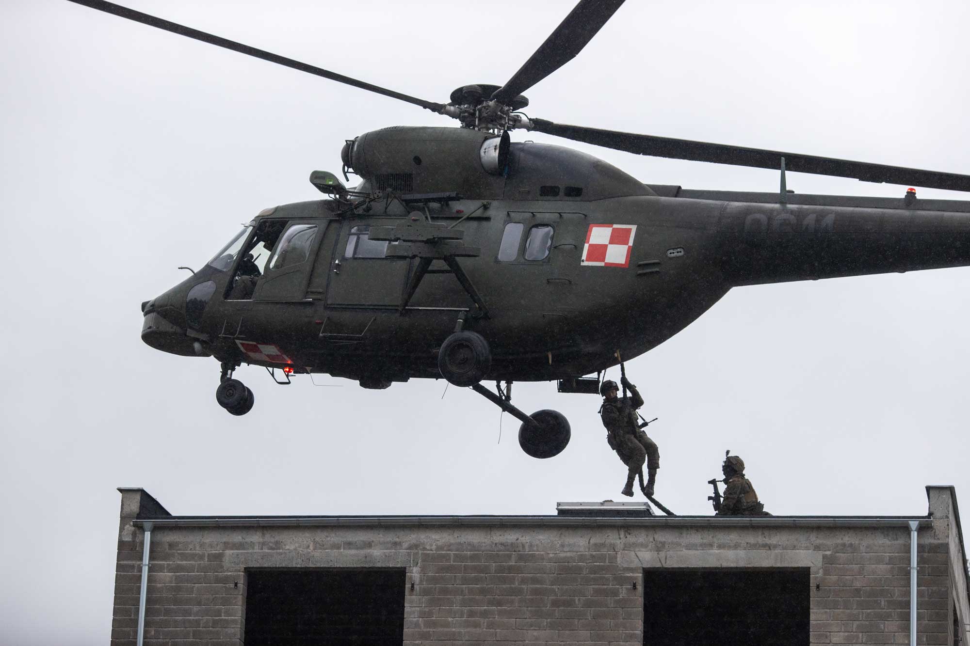 Varios soldados descienden de un helicóptero W-3 Sokól