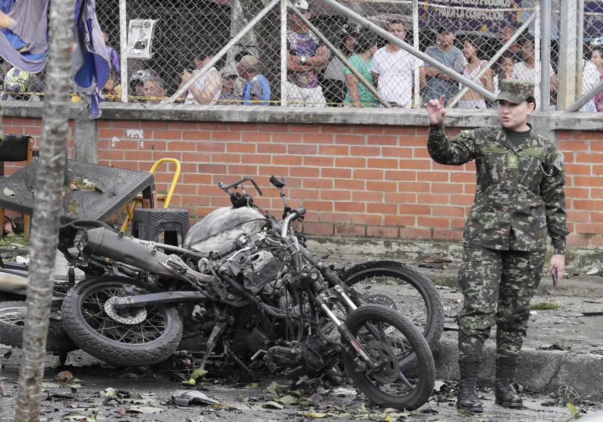 Una integrante del ejército camina al lado de los escombros ocasionados por un atentado