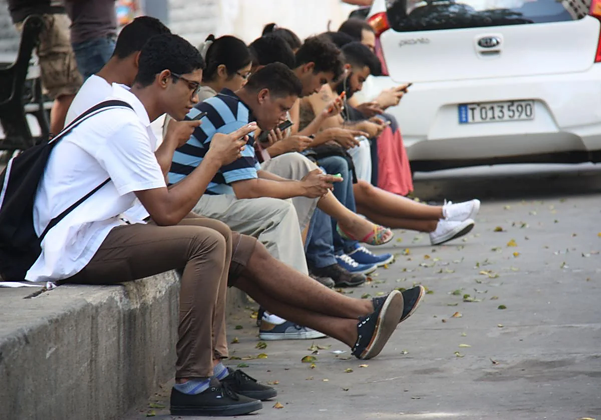 Varios jóvenes hacen uso del móvil en un punto de acceso a internet en La Habana, en una imagen de archivo