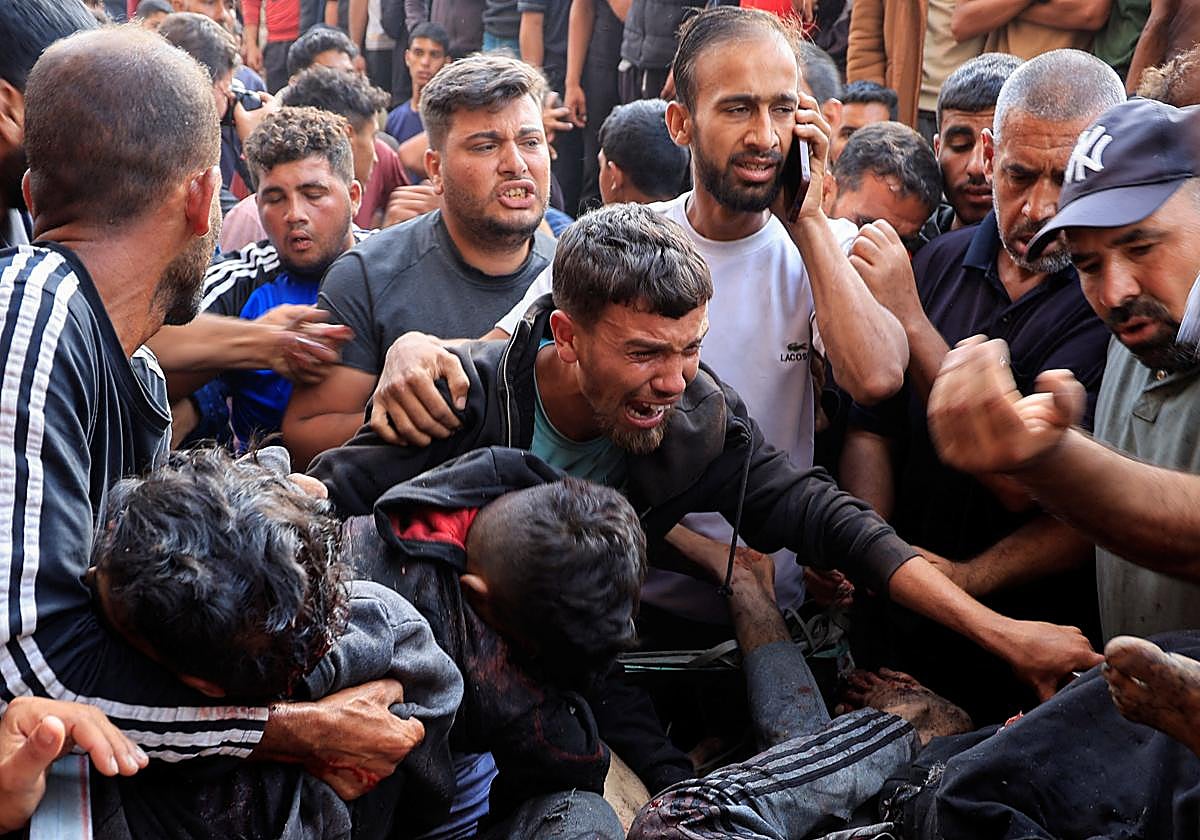 Palestinos reaccionan junto a heridos en un ataque israelí mientras esperaban ayuda en Jan Yunis