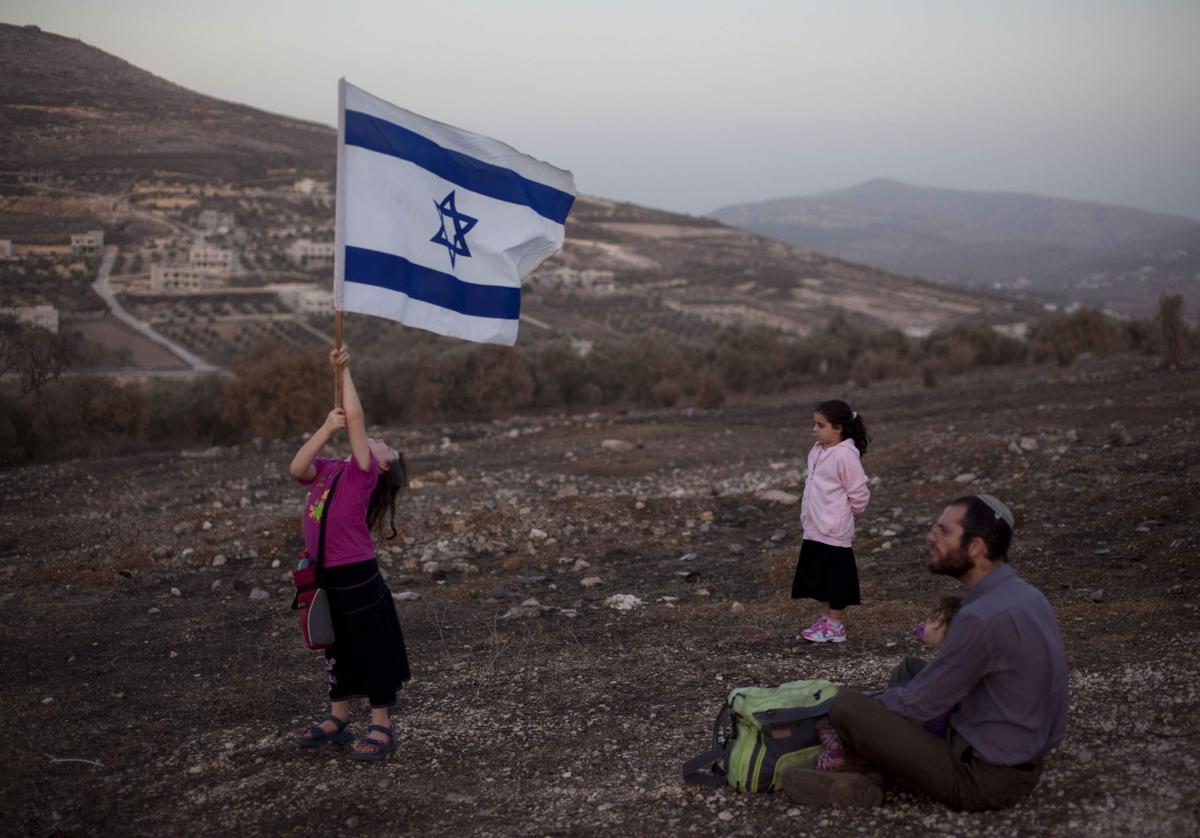 Colonos israelíes con una bandera de Israel, imagen de archivo