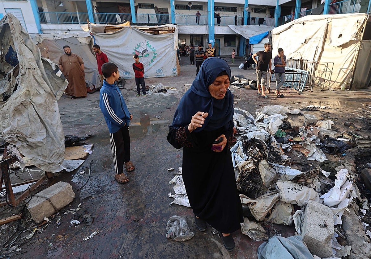 Una mujer camina entre los escombros tras otro ataque en la Franja