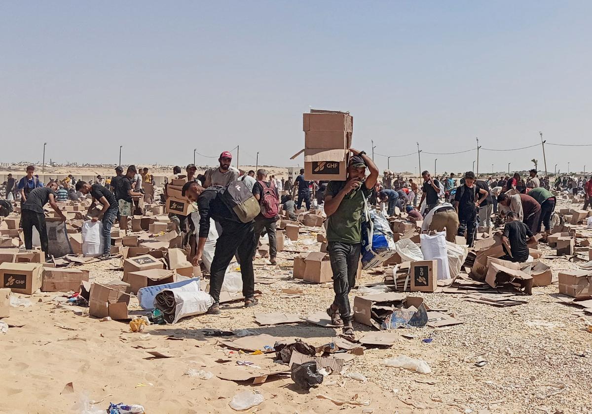 Palestinos recogen lo que queda de suministros de ayuda del centro de distribución de la Fundación Humanitaria de Gaza, respaldada por Estados Unidos.