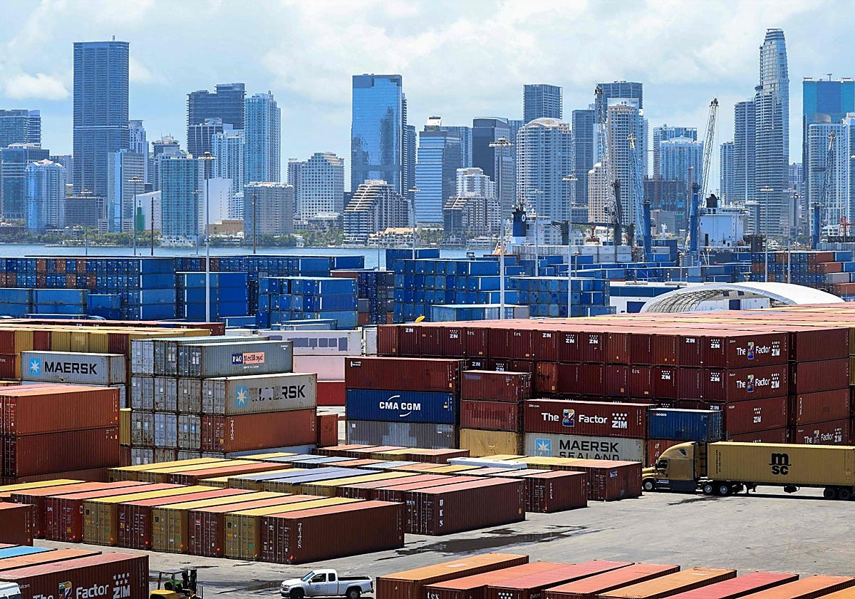 Contenedores con mercancias se apilan en PortMiami mientras los trabajadores manipulan la carga.